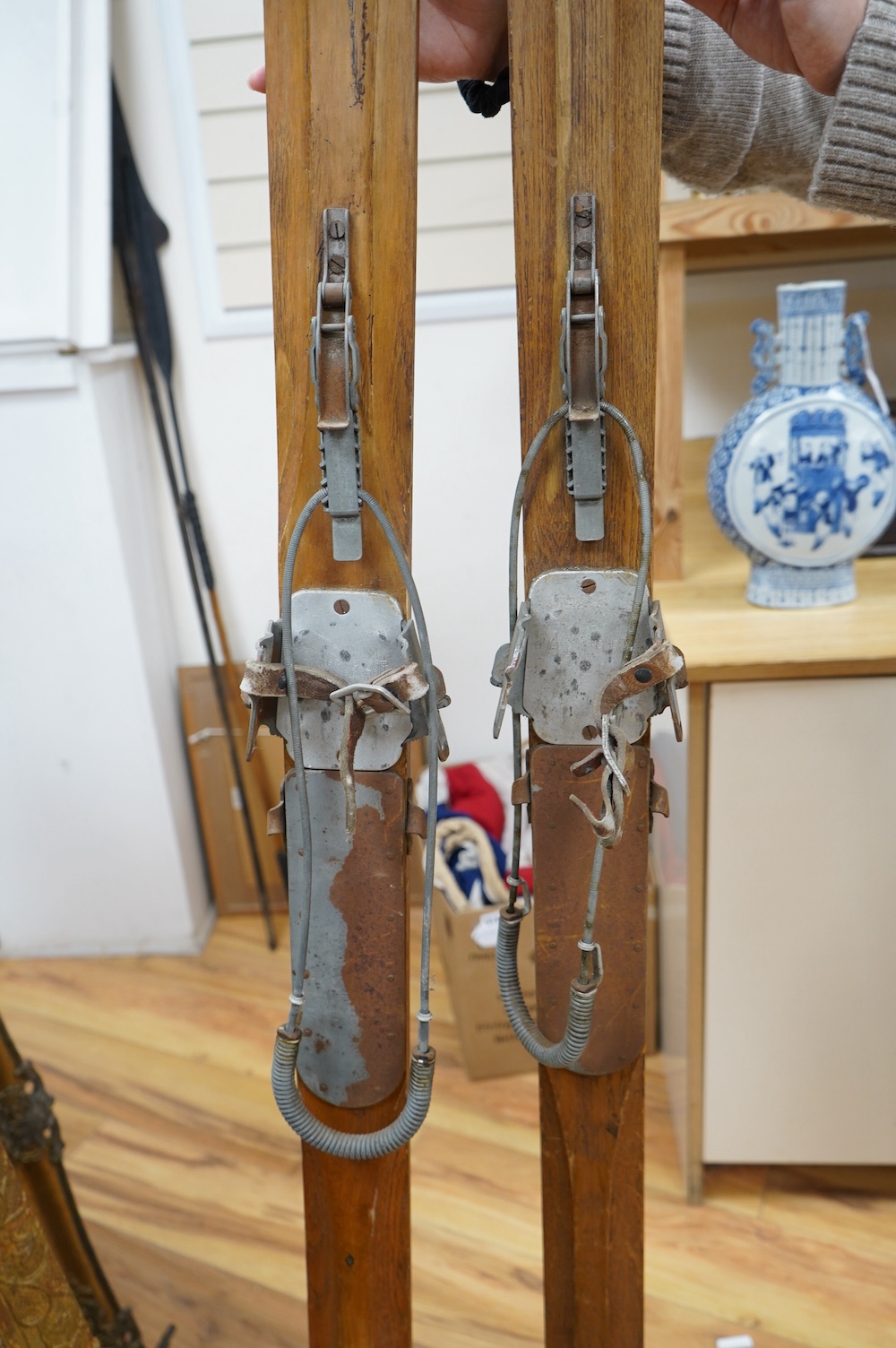 A pair of early 20th century wooden skis with Kandahar metal bindings. 207cm long. Condition - bindings rusty in places leather strapping worn in places, skis appear good but are untested